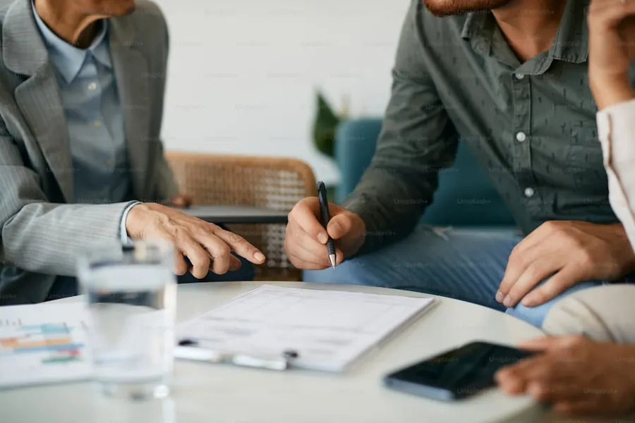 Profesionales revisando documentos en una reunión de gestoría