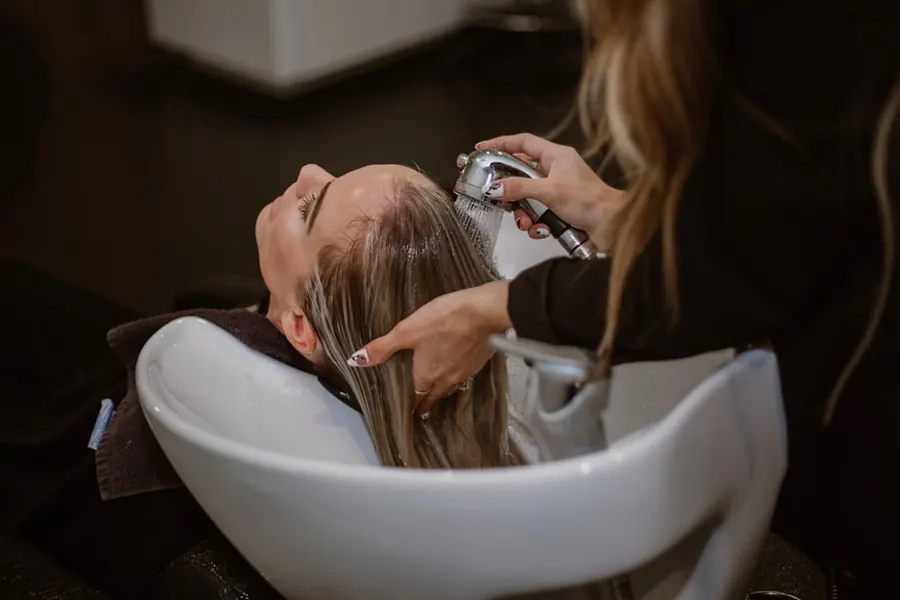 Clienta lavándose el pelo en una peluquería